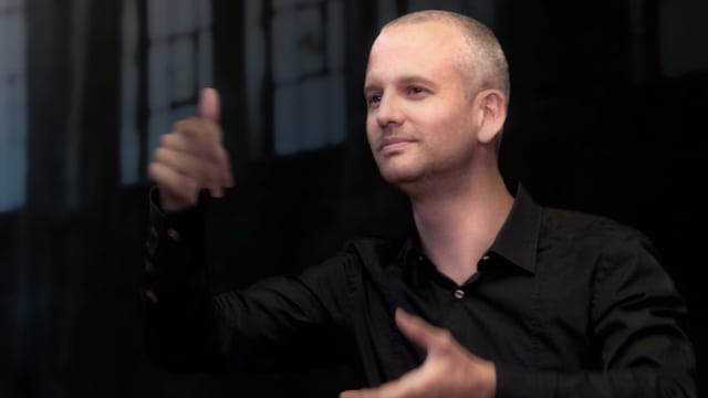 Ein dirigierneder mann mit Kurzhaarfrisur und schwarzem Hemd. Ein dirigierneder mann mit Kurzhaarfrisur und schwarzem Hemd.