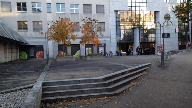 Coop-Laden mit grauem Platz im Vordergrund. Coop-Laden mit grauem Platz im Vordergrund.