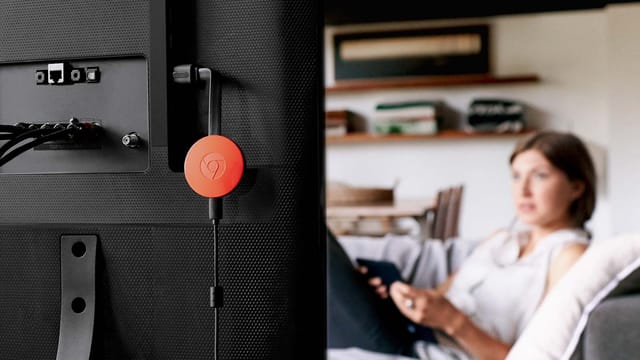 Eine rote Chromecast-Disk baumelt etwas lustlos vom HDMI-Eingang eines Fernsehers herunter. Eine rote Chromecast-Disk baumelt etwas lustlos vom HDMI-Eingang eines Fernsehers herunter.