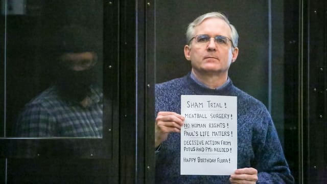 Paul Whelan hält einen Zettel mit Hilferufen hoch. Paul Whelan hält einen Zettel mit Hilferufen hoch.