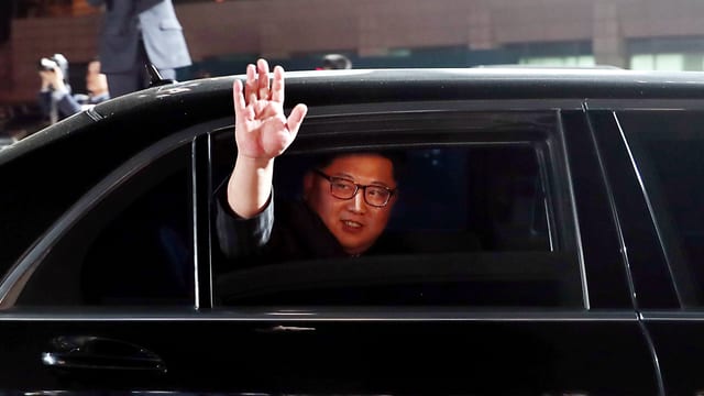 Kim Jong-un winkt aus einer Limousine. Kim Jong-un winkt aus einer Limousine.