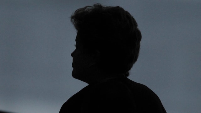 Kopf einer Frau als Silhouette vor dunklem Hintergrund Kopf einer Frau als Silhouette vor dunklem Hintergrund