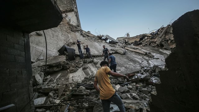 Palästinenser auf den Trümmern eines Hauses in Gaza-Stadt, das von einem israelischen Luftangriff zerstört wurde (19. Mai) Palästinenser auf den Trümmern eines Hauses in Gaza-Stadt, das von einem israelischen Luftangriff zerstört wurde (19. Mai)