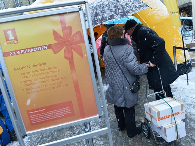 Paar vor Päcklistand.