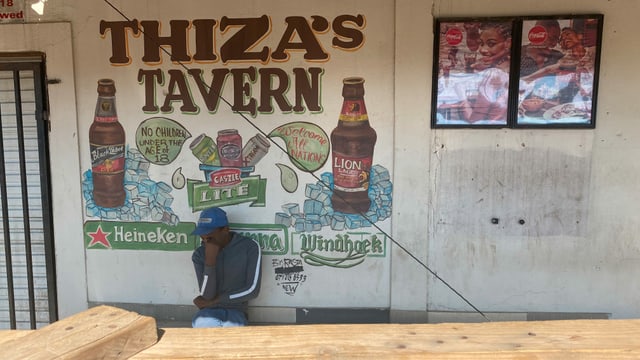 Ein Mann sitzt nachdenklich vor einer Taverne. Ein Mann sitzt nachdenklich vor einer Taverne.