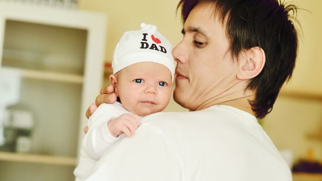 Mann hält Baby im Arm. Mann hält Baby im Arm.