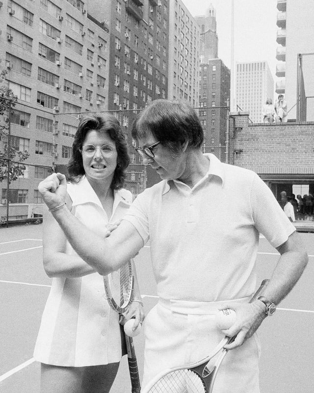 Billie Jean King greift auf dem Tennisplatz nach Bobby Riggs Bizeps. Billie Jean King greift auf dem Tennisplatz nach Bobby Riggs Bizeps.