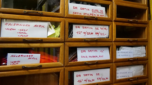 In einem alten Apothekerschrank sind verschiedene Handschuhe sortiert. In einem alten Apothekerschrank sind verschiedene Handschuhe sortiert.