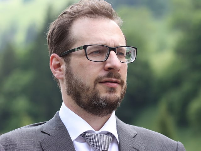 Mann mit schwarzer Brille vor grünem Hintergrund. Mann mit schwarzer Brille vor grünem Hintergrund.