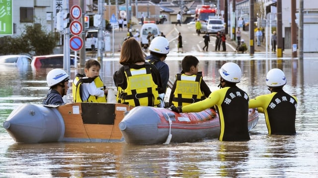 Menschen und Helfer auf und an einem Schlauchboot Menschen und Helfer auf und an einem Schlauchboot