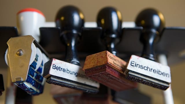 Vier Stempel in einer Reihe aufgehängt. Einer beschriftet mit Betreibungsantrag, einer mti Einschreiben. Vier Stempel in einer Reihe aufgehängt. Einer beschriftet mit Betreibungsantrag, einer mti Einschreiben.