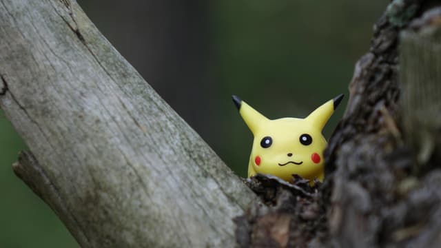 Ein Pikachu-Pokémon sitzt in einer Astgabel. Ein Pikachu-Pokémon sitzt in einer Astgabel.