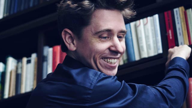 Michael Fehr steht vor einem grossen Bücherregal. Michael Fehr steht vor einem grossen Bücherregal.