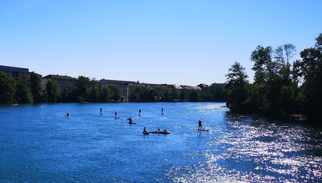 Breiter Fluss an einem Sommertag, darauf viele Paddler. Breiter Fluss an einem Sommertag, darauf viele Paddler.