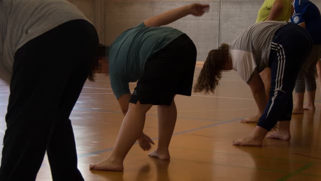 Die Teilnehmer machen Übungen in einer Turnhalle. Die Teilnehmer machen Übungen in einer Turnhalle.