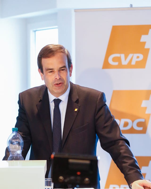 Pfister spricht auf einem Podium. Hinter ihm das orange Parteilogo. Pfister spricht auf einem Podium. Hinter ihm das orange Parteilogo.