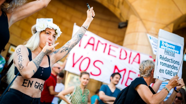 Frau pfeift mit dem Mund, im Hintergrund Menschen mit Transparenten Frau pfeift mit dem Mund, im Hintergrund Menschen mit Transparenten