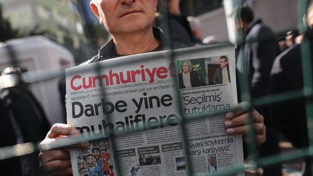 Ein Demonstrant hält eine Ausgabe der Cumhuriyet (Archivbild). Ein Demonstrant hält eine Ausgabe der Cumhuriyet (Archivbild).