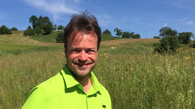 Mann in hellgrünem Hemd vor Wiese. Mann in hellgrünem Hemd vor Wiese.