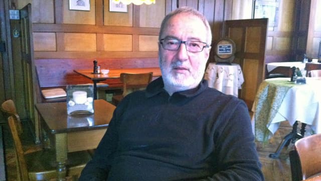Dani Schütz sitzt an einem Holztisch in seinem Restaurant Ochsen in Oberzeihen Dani Schütz sitzt an einem Holztisch in seinem Restaurant Ochsen in Oberzeihen
