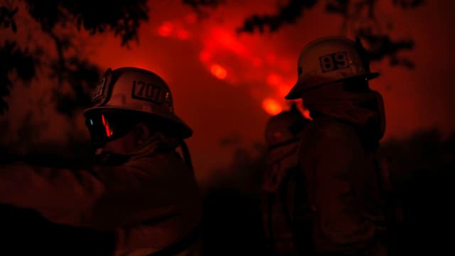 Zwei Feuerwehrmänner vor einem Buschbrand in Kalifornien Zwei Feuerwehrmänner vor einem Buschbrand in Kalifornien