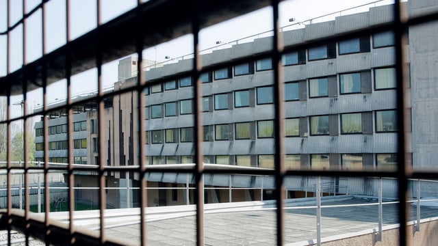 Gitterstäbe vor einem Gefängniskomplex. Gitterstäbe vor einem Gefängniskomplex.
