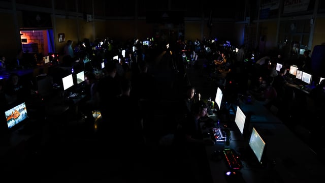 Dunkler Saal mit leuchtenden Computerbildschirmen Dunkler Saal mit leuchtenden Computerbildschirmen