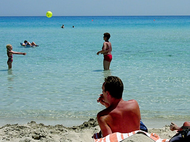 Ein Mann sonnt sich am Strand. Ein Mann sonnt sich am Strand.