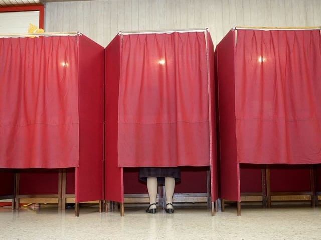 Eine Frau gibt im Wahllokal ihre Stimme ab. Eine Frau gibt im Wahllokal ihre Stimme ab.
