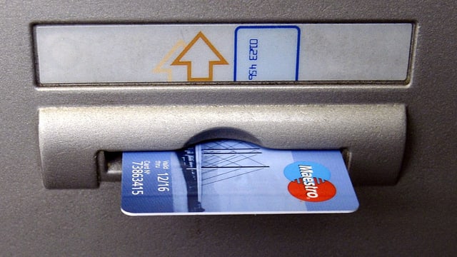 Maestro-Karte in einem Bankomatenschlitz. Maestro-Karte in einem Bankomatenschlitz.