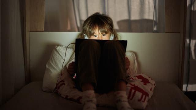 Mädchen mit Tablet auf dem Schoss. Mädchen mit Tablet auf dem Schoss.