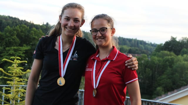 Zwei junge Frauen mit Goldmedaillen um den Hals Zwei junge Frauen mit Goldmedaillen um den Hals