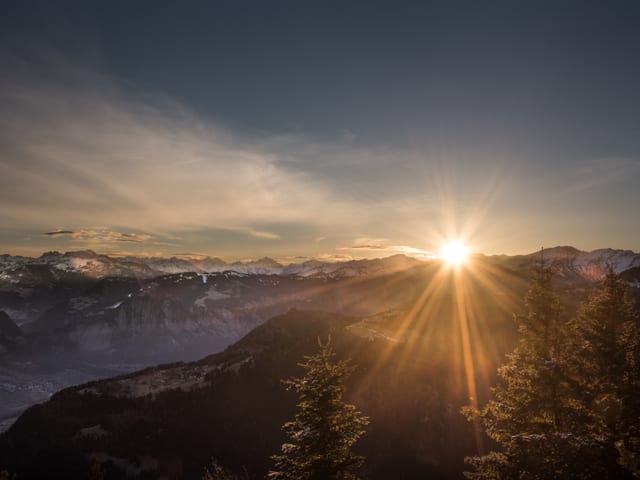 Die Sonne versteckt sich hinter den Bergen.