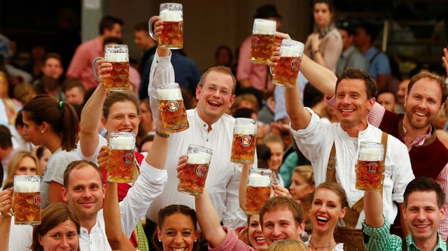 Feiernde mit Mass in der Hand prosten sich zu. Feiernde mit Mass in der Hand prosten sich zu.