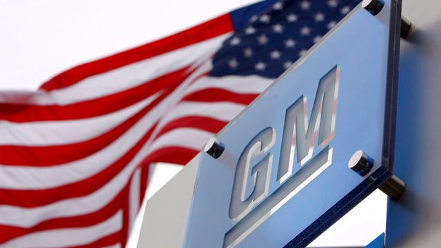 GM-Logo mit US-Flagge dahinter GM-Logo mit US-Flagge dahinter