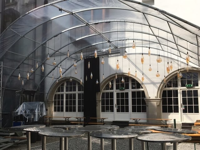 Plexiglasdach mit Hängelampen in einem Innenhof Plexiglasdach mit Hängelampen in einem Innenhof