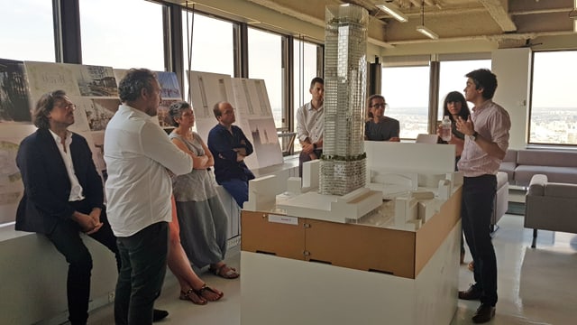 Eine Gruppe von Personen stehen um ein Architekturmodell Eine Gruppe von Personen stehen um ein Architekturmodell