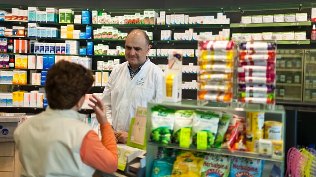 Ein Apotheker berät eine Kundin. Ein Apotheker berät eine Kundin.