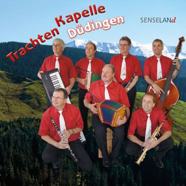 Rote Hemden und weisse Krawatten. Die Band sitzt vor Bergkulisse. Rote Hemden und weisse Krawatten. Die Band sitzt vor Bergkulisse.