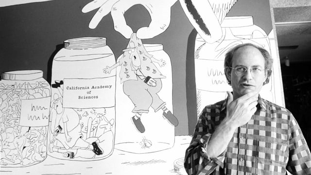 Ein Mann steht vor einem Cartoon, der Gläser mit kleinen Figürchen zeigt. Ein Mann steht vor einem Cartoon, der Gläser mit kleinen Figürchen zeigt.