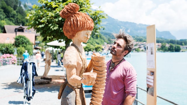 Ein Mann bestaunt seine Holzskulptur Ein Mann bestaunt seine Holzskulptur