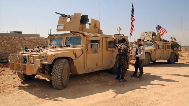 Amerikanische Militärfahrzeuge und syrische Kämpfer Amerikanische Militärfahrzeuge und syrische Kämpfer