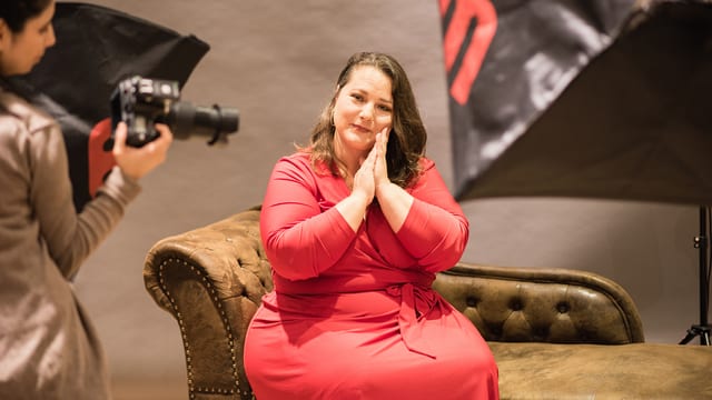 Eine füllige Frau im roten Kleid bei einem Fotoshooting. Eine füllige Frau im roten Kleid bei einem Fotoshooting.