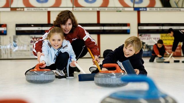 Junge Curlerinnen und Curler auf dem Eisfeld Junge Curlerinnen und Curler auf dem Eisfeld