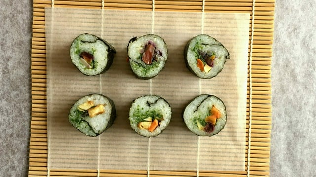 6 Sushi mit Wurzelgemüse statt Fisch auf einem Sushi-Mättchen aus Bambus. 6 Sushi mit Wurzelgemüse statt Fisch auf einem Sushi-Mättchen aus Bambus.