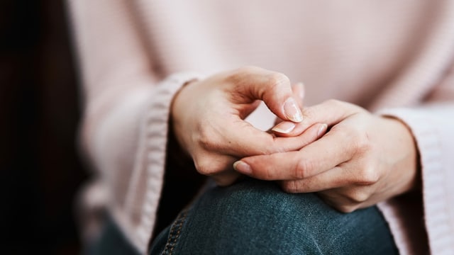 Frau mit rosa Pullover verschränkt die Hände Frau mit rosa Pullover verschränkt die Hände