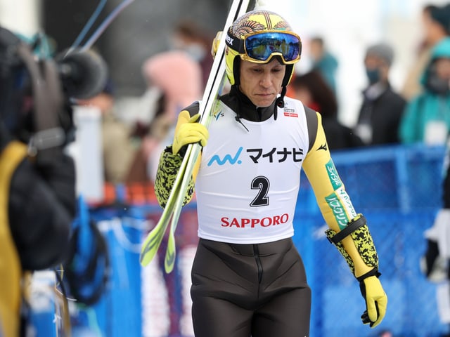 Noriaki Kasai trägt die Ski Noriaki Kasai trägt die Ski