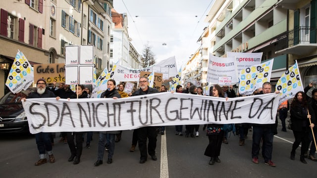 Mitarbeiter der SDA protestieren mit Transparenten auf der Strasse Mitarbeiter der SDA protestieren mit Transparenten auf der Strasse