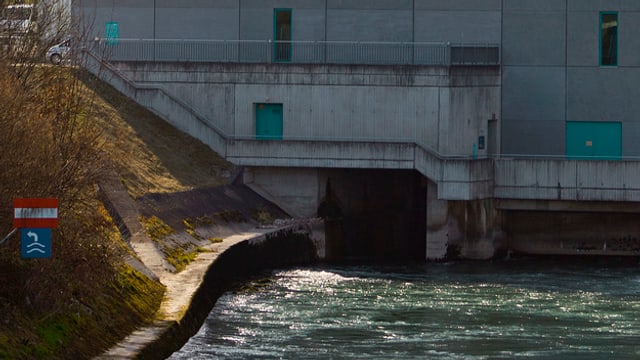 Nahaufnahme Fluss fliessst in eine Betonwand des Kraftwerks Nahaufnahme Fluss fliessst in eine Betonwand des Kraftwerks