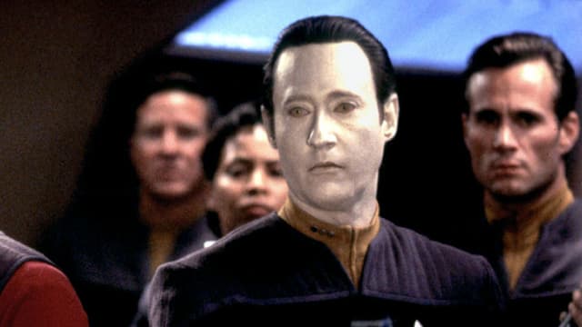 Der Androide Data sticht mit seinem sehr weissen Gesicht heraus aus einer Gruppe von vier Leuten. Der Androide Data sticht mit seinem sehr weissen Gesicht heraus aus einer Gruppe von vier Leuten.